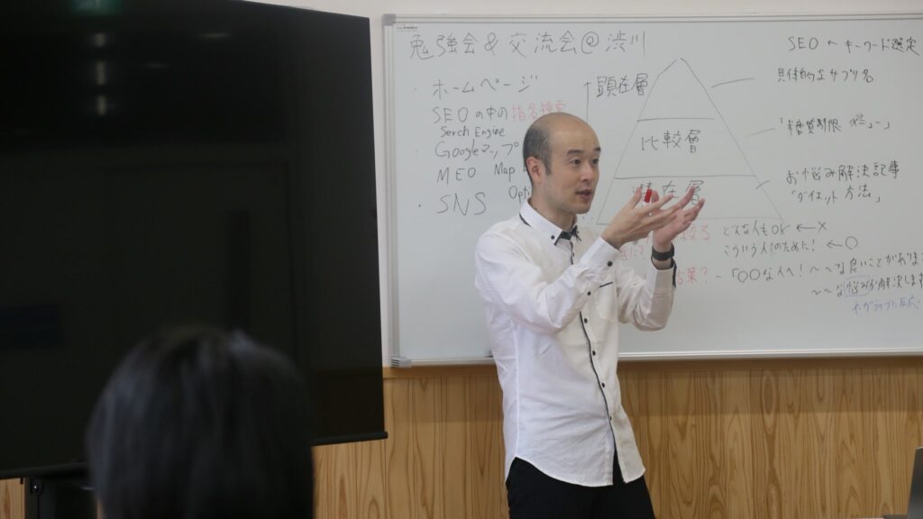 ホワイトボードの前に立って話す梅澤浩太郎